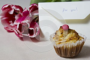Cupcake with the letter and a bouquet on a table