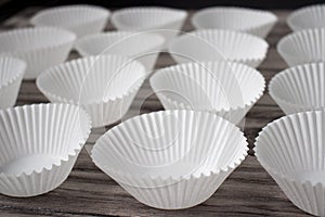 Cupcake Liners Empty Muffin Forms Arranged on a Wooden Table.