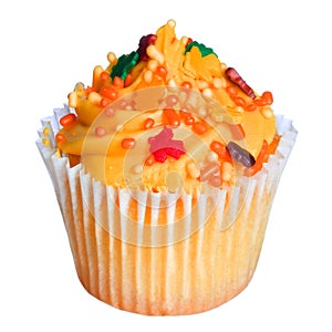 Cupcake with orange frosting and colored sprinkles isolated on white. Sweet food for Halloween