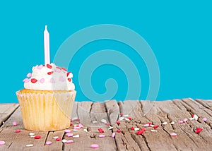 Cupcake with pink candle and heart sprinkles