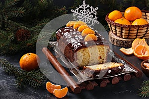 Cupcake with tangerines, covered with chocolate glaze is located on the New Year`s background, Festive still life