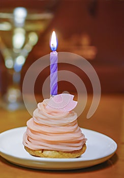 cupcake topped with a birthday candle and a glass of champagne