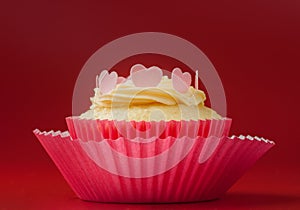 Nice vanilla cupcake with icing and eatable hearts photo