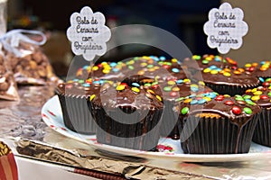 Cupcake varieties with decorative plate with the phrase `Carrot cake with brigadier` on the wooden table