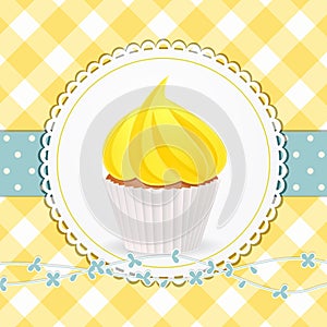 Cupcake with yellow icing on yellow gingham background