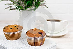Cupcakes with black currant and mint leaves on a white plate. Selective focus.