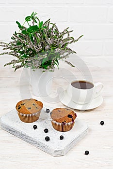 Cupcakes with black currant and mint leaves on a white plate. Selective focus.