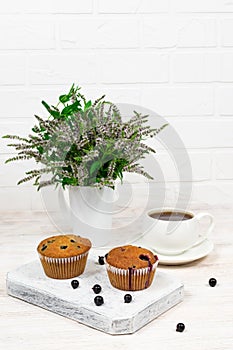 Cupcakes with black currant and mint leaves on a white plate. Selective focus.