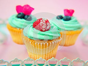 Cupcakes with butter cream and vanilla with raspberry and blueberry