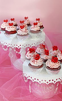 Cupcakes decorated with red roses and hearts for Valentine or weddings