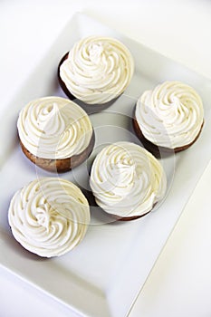 Cupcakes with frosting on white vertical