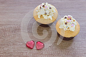 A cupcakes with heart shape chocolate on wooden table