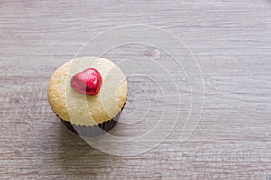 A cupcakes with heart shape chocolate on wooden table