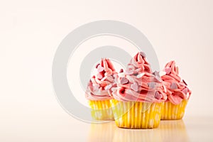 Cupcakes, three Pink cupcakes with heart shaped sprinkles on white background, copy space
