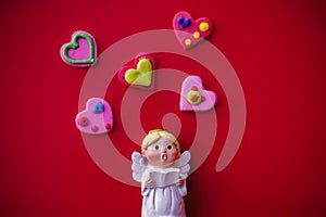 Cupid doll and heart-shaped on red background