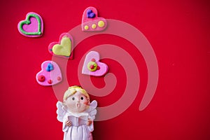 Cupid doll and heart-shaped on red background