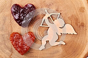 Cupid near heart-shaped jelly bread.