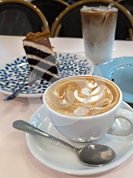 Cuppacino coffee with cakes on the table for tea time