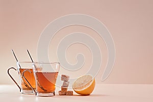 Cups with aromatic black tea. Pieces of brown sugar. Part of juicy lemon. Team composition on pink backdrop. Copy space