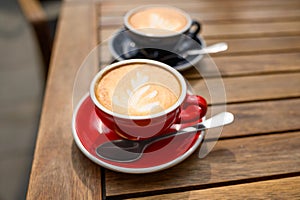 Cups of aromatic coffee on wooden table