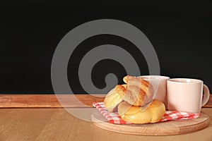 Cups and baked goods on wooden table