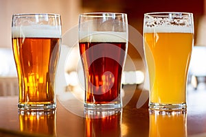 Cups of beer on a wooden table with a blurred background