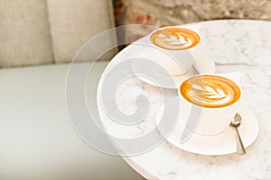 Cups of cappuccino on the white marble table in a modern cafe
