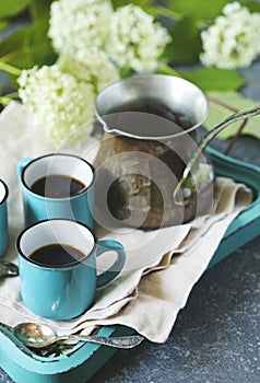 Cups of coffee and copper cerve on tray.