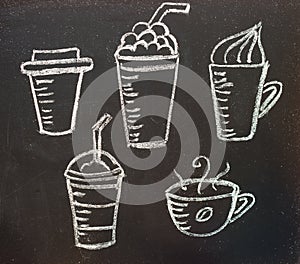 Cups with coffee drawn in chalk on a blackboard.