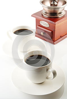 Cups of coffee with saucer and mill on white photo