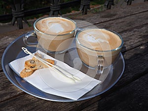 Cups of fresh Cappuccino coffee latte served with coockies photo