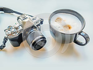 Cups of latte and camera on a white background