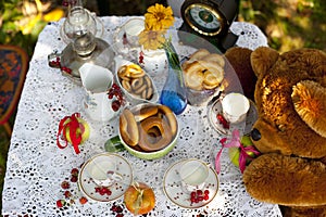 Cups with milc, bowls with cakes and fresh berries - raspberry, cherry - on tablecloth