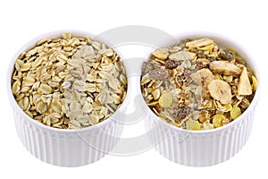 Cups of raw rolled oats and packaged muesli isolated on white