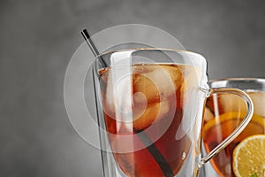 Cups of refreshing iced tea against grey, closeup