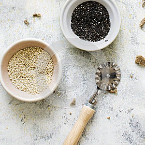 Cups of sesame by a roller knife cutter in a kitchen flatlay