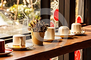 Cups on the shelf in warm sunlight in Romantic Atmosphere of Coffee Shop