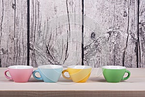 Cups on table over wooden background