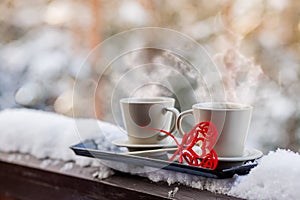 Cups of tea or coffee with steam,heart shape on blurred background. Valentine`s day celebration or love concept. Copy