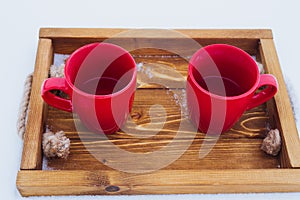 Cups on a tray in snow, winter picnic