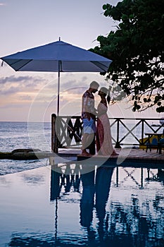 Curacao, couple on vacation in Curacao watching sunset by the pool