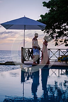 Curacao, couple on vacation in Curacao watching sunset by the pool