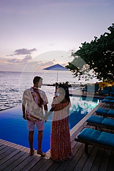 Curacao, couple on vacation in Curacao watching sunset by the pool