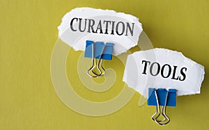 CURATION TOOLS - the words is printed on a white piece of paper on a yellow background