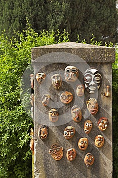 The curbstone in a garden, decorated ceramic ritual masks