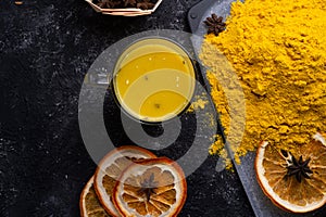 Curcuma turmeric spice , curcuma cocktail served with dry oranges at black table. Food and cuisine ingredients. healthy concept