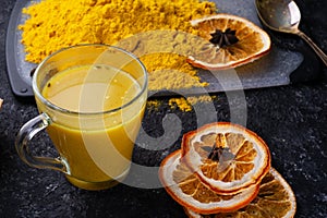 Curcuma turmeric spice , curcuma cocktail served with dry oranges at black table. Food and cuisine ingredients. healthy concept