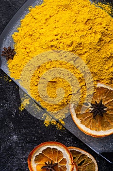 Curcuma turmeric spice with dry oranged served at black table. Food and cuisine ingredients. healthy concept. close up. flat lay