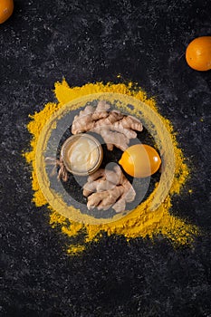 Curcuma (turmeric) spice   ginger  lemon and honey served at black table. healthy concept. flat lay