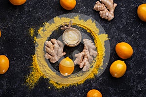 Curcuma (turmeric) spice   ginger  lemon and honey served at black table. healthy concept. flat lay